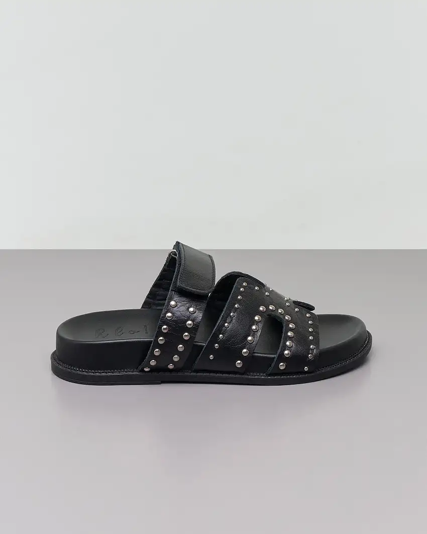 Sandali bassi neri in pelle con borchiette argento applicate sulla fibbia con chiusura a strappo