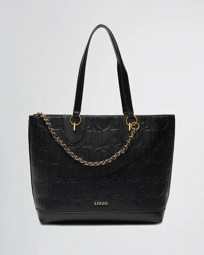 Shopping bag nera in similpelle con motivo logo a rilievo all over embossed e catena decorativa intarsiata