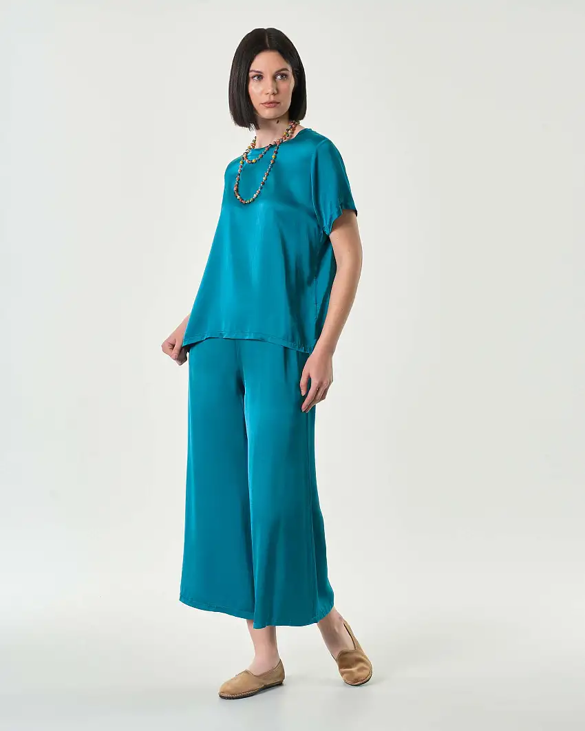 Pantaloni cropped color ottanio in raso di viscosa e seta dalla linea ampia con elastico in vita