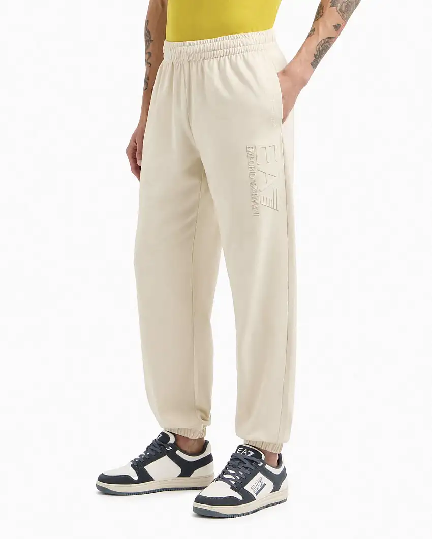 Pantalone EA7 beige in felpa con maxi logo gommato in tono sulla gamba sinistra