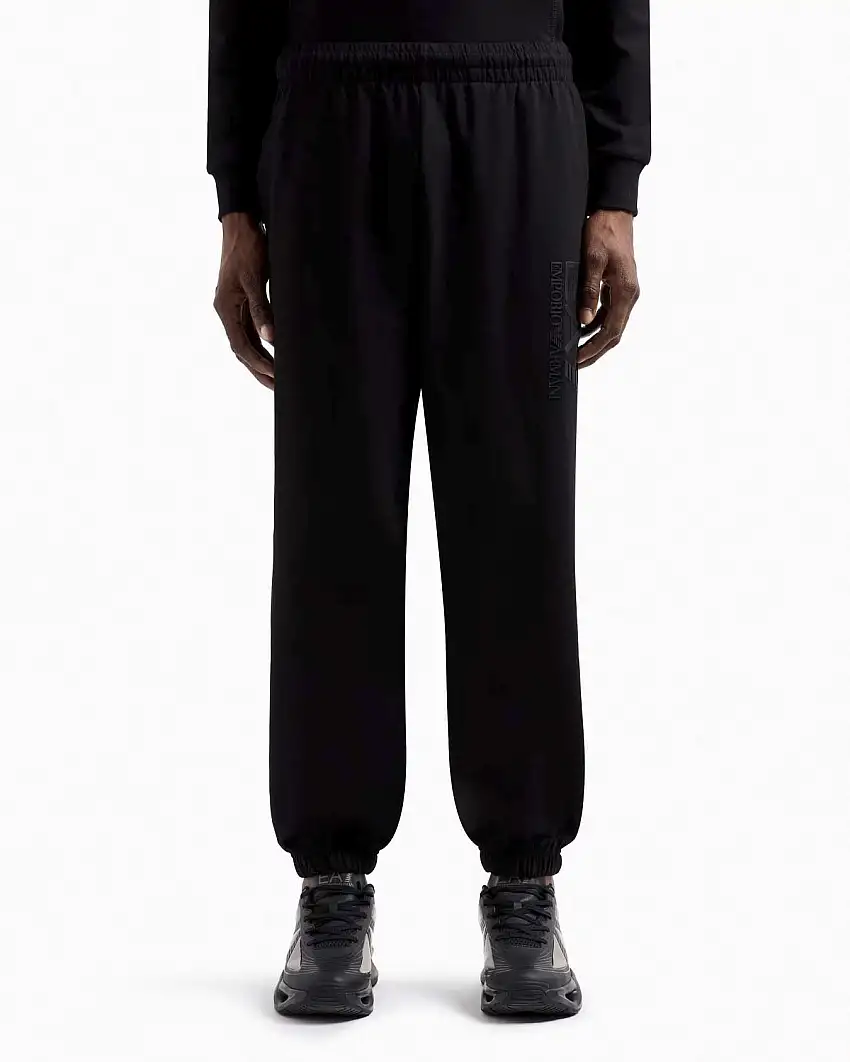 Pantalone EA7 nero in felpa con maxi logo gommato in tono sulla gamba sinistra